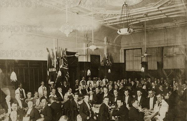 Burns Night in Bombay. A large group of formally dressed British gentlemen pose for the camera, seated around long tables for a Burns Night supper. Bombay (Mumbai), India, circa 1920. Mumbai, Maharashtra, India, Southern Asia, Asia.