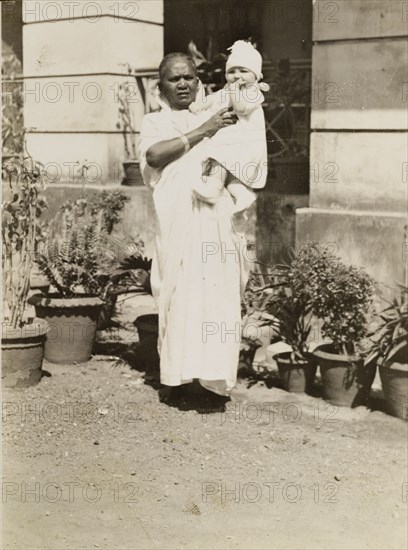 Ayah with baby. Outdoors portrait of an Indian ayah (nursemaid) with a British baby. India, circa 1927. India, Southern Asia, Asia.