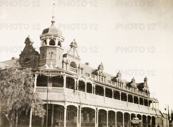 Grand Hotel in Bulawayo. Frontal view of the Grand Hotel in Bulawayo. The building features colonial-style architecture with a veranda running the length of the first and second storeys, and a turret and dormer windows adorning the roof. Bulawayo, Southern Rhodesia (Zimbabwe), circa 1930. Bulawayo, Zimbabwe, Southern Africa, Africa.