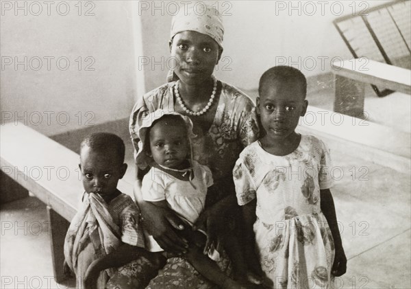 Female student of a missionary college. Portrait of an African woman with her three children, a student of a Methodist missionary college in Mombasa. Mombasa, Kenya, circa 1957. Mombasa, Coast, Kenya, Eastern Africa, Africa.