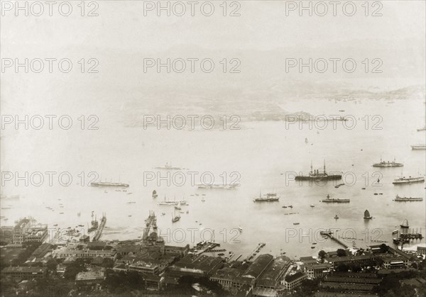View across Hong Kong harbour, 1903. View over Hong Kong harbour looking across to Kowloon: an area known today as 'Admiralty'. Numerous vessels float in the harbour, including the triple-masted HMS Tamar, steamships, launches and Chinese junks. Hong Kong, China, 1903. Hong Kong, Hong Kong, China, People's Republic of, Eastern Asia, Asia.