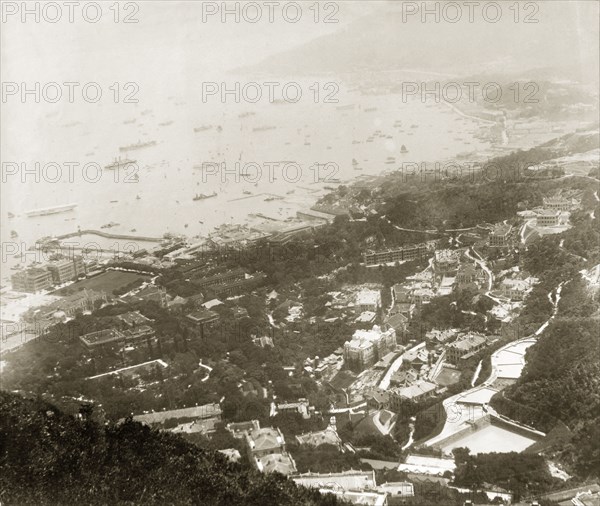 The eastern front of Hong Kong harbour. View over the eastern front of Hong Kong harbour, an area known today as 'Admiralty'. An original caption points out HMS Tamar, moored near the partially completed Admiralty Dock (centre), the Hong Kong Club (left) and the domed roof of the Shanghai Bank further inland. Hong Kong, China, 1905. Hong Kong, Hong Kong, China, People's Republic of, Eastern Asia, Asia.