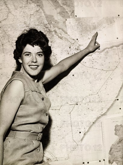 Susan de Heveningham Baekeland. Susan de Heveningham Baekeland, the first female Assistant Adviser to the South African Federation, points to a map of Africa as she smiles for the camera. Nairobi, Kenya, 1963. Nairobi, Nairobi Area, Kenya, Eastern Africa, Africa.
