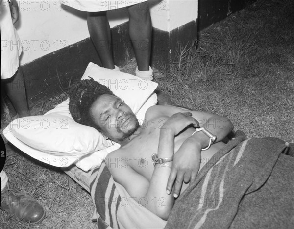 Portrait of Dedan Kimathi. Dedan Kimathi lies handcuffed on the ground shortly before his execution by the British colonial government. Kenya, 21 October 1956. Kenya, Eastern Africa, Africa.