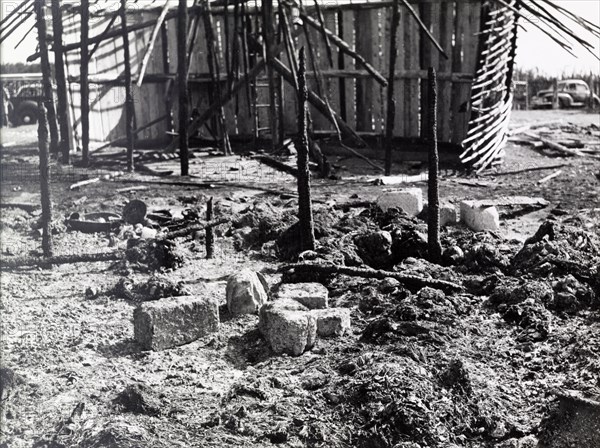 Destruction after a Mau Mau raid. The charred remains of a village destroyed in a raid by Mau Mau fighters. Kenya, circa 1953. Kenya, Eastern Africa, Africa.