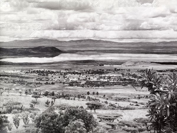 View of Lake Nakuru, Kenya. Panoramic view over rolling scrubland looking towards Lake Nakuru, which the photographer notes with surprise, is full of water. Kenya, circa 1953. Kenya, Eastern Africa, Africa.