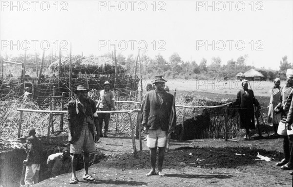 Home Guards at a Kikuyu security village. Armed Kikuyu Home Guards at a fortified security village. To the left, Kikuyu men can be seen digging a moat to provide further protection against Mau Mau attack. Kenya, circa 1955. Kenya, Eastern Africa, Africa.