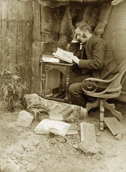 Reverend Thomas St John Parry Pughe. Staged outdoors portrait of 'Tom', the Reverend Thomas St John Parry Pughe, studying with books. Probably Toowoomba, Australia, circa 1895. Toowoomba, Queensland, Australia, Australia, Oceania.