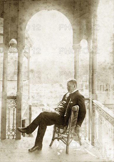 Dr Taylor relaxes at 'Nundora'. A well-dressed gentleman identified as 'Dr Taylor' relaxes with a newspaper on the veranda of 'Nundora', the Brodribb family's house. Toowoomba, Australia, circa 1895. Toowoomba, Queensland, Australia, Australia, Oceania.