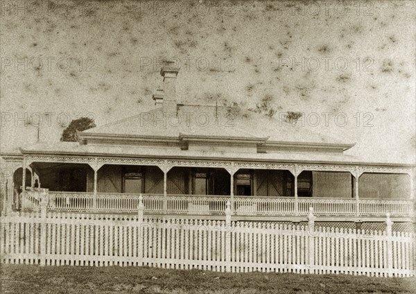 House called 'Nundora', Australia. The Brodribb family's house 'Nundora' surrounded by a white picket fence. The house is colonial in style with a veranda running around three of its sides and a gabled roof supported by pillars. Toowoomba, Australia, circa 1890. Toowoomba, Queensland, Australia, Australia, Oceania.