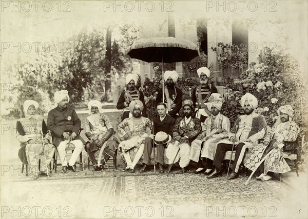A group of Indian chiefs. A British Lieutenant Governor of the Punjab poses for a group portrait with eight Indian chiefs, his non-descript outfit contrasting sharply with the opulent dress of the Indian men. The group is accompanied by three uniformed servants, one of whom holds a parasol. Punjab, India, circa 1895., Punjab, India, Southern Asia, Asia.