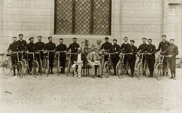 A Victorian gentlemen's bicycle group. Identified as 'The 1st Buffs' bicycle section', British cyclists in dark sports uniforms line up for a group portrait with their bicycles. India, circa 1895. India, Southern Asia, Asia.