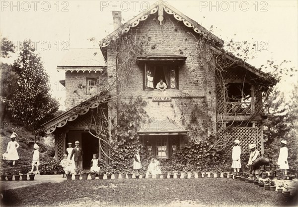 The Blount family at Roseneath. Pakistani servants dressed in white tend to the Blount family as they relax in the gardens of their house, 'Roseneath'. One individual waters the family's numerous potted plants from a large water bag supported on his shoulder. Murree, Punjab, India (Punjab, Pakistan), circa 1895. Murree, Punjab, Pakistan, Southern Asia, Asia.