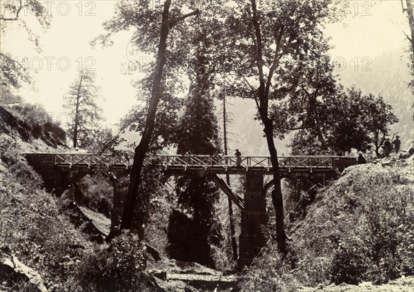 Bridge on the way to Kashmir. A distant figure peers over the side of a wooden road bridge, constructed across a ravine in the Himalayan mountains on the way to Kashmir. India, circa 1895., Jammu and Kashmir, India, Southern Asia, Asia.