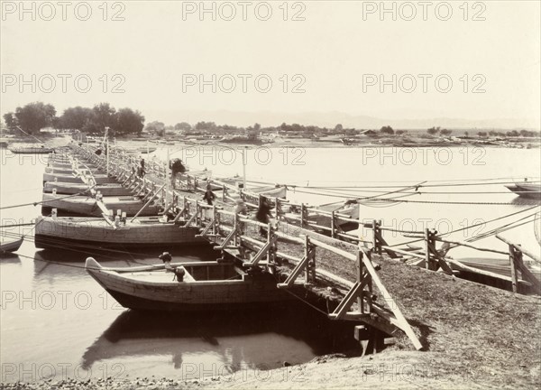 A floating bridge of canoes. A line of canoes, tethered together and permanently moored, provide support for a floating bridge across the Indus River. India (Pakistan), circa 1895., Punjab, Pakistan, Southern Asia, Asia.