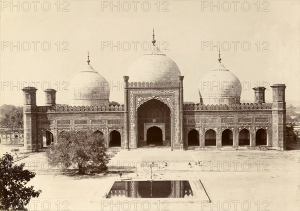 A mosque with three domes. A mosque built in typical Islamic style is decorated with features including three domes, a series of arched doorways and corner minarets. India, circa 1895. India, Southern Asia, Asia.