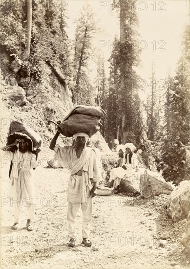 Mountain mail runners. Mail runners balance large sacks of letters on their heads as they travel along a Himalayan mountain track. India, circa 1895., Jammu and Kashmir, India, Southern Asia, Asia.