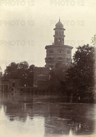 Ornate Hindu temple. An ornate Hindu temple perched on the edge of a lake is silhouetted against the sky. India, circa 1895. India, Southern Asia, Asia.