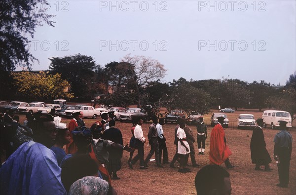 Funeral of Professor Brown. A procession of mourners comprising academic university staff attend the funeral of their colleague, Professor Brown. Nigeria, circa 1969. Nigeria, Western Africa, Africa.