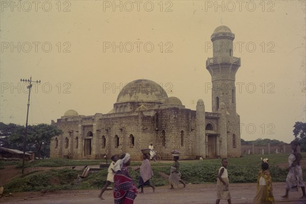Mosque at Okene. Passers-by near a mosque at Okene. Okene, Nigeria, circa 1964. Okene, Kogi, Nigeria, Western Africa, Africa.