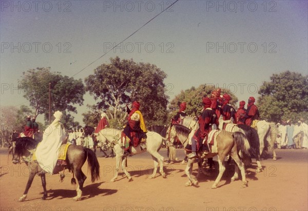 Procession for Ramadan. A group of Nigerian men dressed in ceremonial attire ride horseback in a procession celebrating the end of Ramadan. Zaria, Nigeria, 1958. Zaria, Kaduna, Nigeria, Western Africa, Africa.