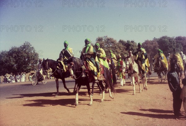 Procession for Ramadan. A group of Nigerian men dressed in ceremonial attire ride horseback in a procession celebrating the end of Ramadan. Zaria, Nigeria, 1958. Zaria, Kaduna, Nigeria, Western Africa, Africa.