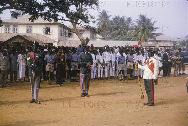 Fajuyi's state funeral. Uniformed military men perform a salute in front of crowds gathered for the state funeral of Lieutenant Colonel Francis Adekunle Fajuyi. Ado Ekiti, Nigeria, 1966. Ado Ekiti, Ekiti, Nigeria, Western Africa, Africa.