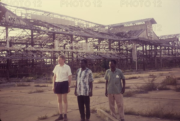 The remains of Onitsha market. Three men stand in front of the skeletal remains of the old market at Onitsha, a victim of raids carried out during the Nigerian Civil War (1967-70). Onitsha, Nigeria, circa 1970. Onitsha, Anambra, Nigeria, Western Africa, Africa.