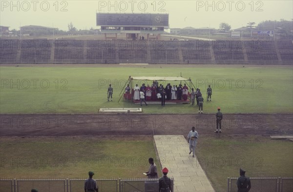 Thanksgiving ceremony, Nigeria. A group of Christian priests gather beneath a small canopy at Liberty Stadium to give thanks for the end of the Nigerian Civil War (1967-70). Ibadan, Nigeria, circa February 1970. Ibadan, Oyo, Nigeria, Western Africa, Africa.