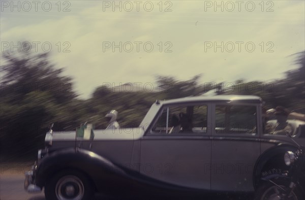 General Gowon whizzes past. General Gowon, Head of the Federal Military Government of Nigeria, whizzes past in a car accompanied by a police escort. Nigeria, circa January 1970. Nigeria, Western Africa, Africa.