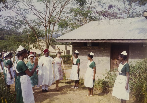 Governor Fadahunsi is greeted by nurses. Sir Chief Joseph Odeleye Fadahunsi (b.1901), Governor of Western Nigeria from December 1962 to January 1966, is greeted by uniformed nurses on his visit to a Church of Nigeria hospital. Nigeria, November 1963. Nigeria, Western Africa, Africa.