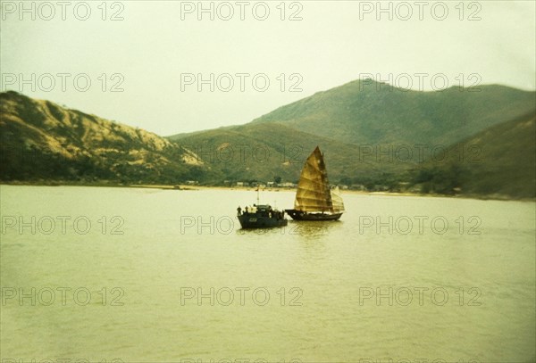 Chinese gun boat. A Chinese gun boat off the coast of Macau sails alongside a traditional Chinese junk. Macau, People's Republic of China, January 1961. Macau, Macau, China, People's Republic of, Eastern Asia, Asia.