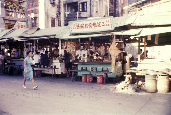 Chow stalls on a city street. Chow stalls vie for trade, selling fast food to passing customers on a city side street. Wan Chai, Hong Kong, People's Republic of China, July 1960. Wan Chai, Hong Kong, China, People's Republic of, Eastern Asia, Asia.