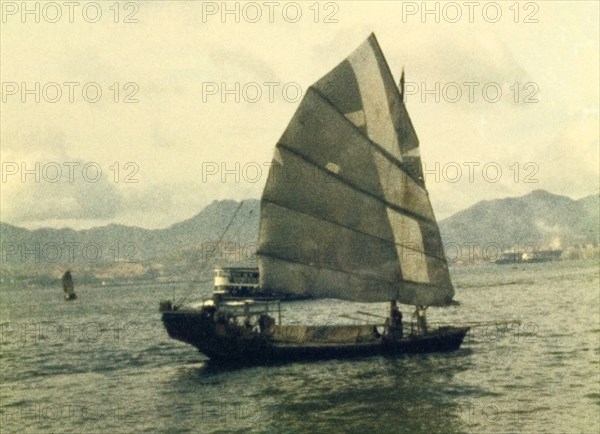 A Chinese junk. A Chinese junk sails off the coastline of Hong Kong. Hong Kong, People's Republic of China, July 1960. Hong Kong, Hong Kong, China, People's Republic of, Eastern Asia, Asia.