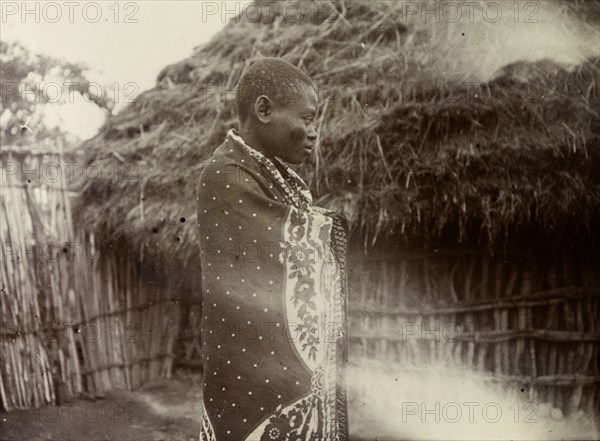 Ugandan woman. Profile shot of a Ugandan woman wrapped in a patterned cloth. Uganda, 1906. Uganda, Eastern Africa, Africa.