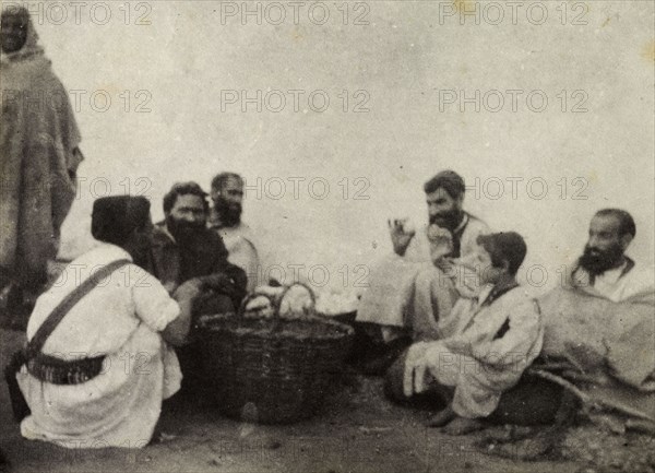 Jewish egg merchants. A group of Jewish egg merchants chat in a group around baskets containing their wares. Morocco, 1898. Morocco, Northern Africa, Africa.