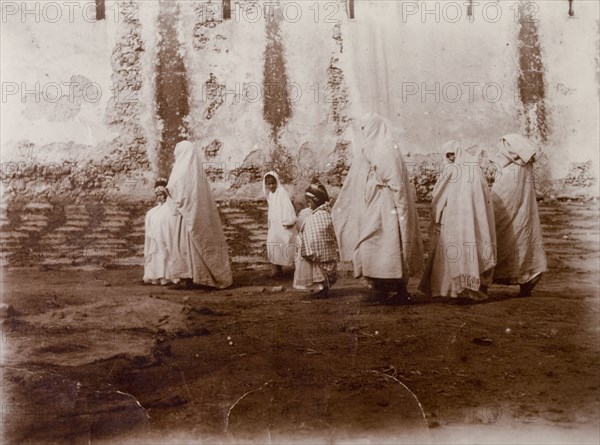 Moroccan women and children. Moroccan women shrouded in robes and headscarves marshal their children along the road. Morocco, 1898. Morocco, Northern Africa, Africa.