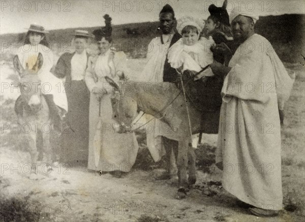 The Russi children on a donkey ride. A European governess and two Moroccan servants accompany Mrs Russi and her children on a donkey ride. The Europeans all wear typical Victorian dress. Safi, Morocco, 1898. Safi, Safi, Morocco, Northern Africa, Africa.
