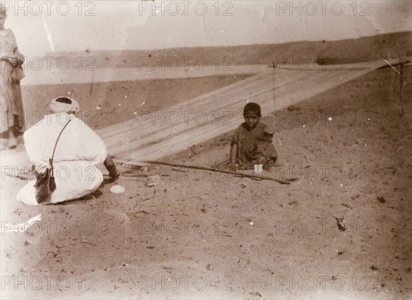 Rope making, Morocco. A Moroccan man works in the desert, stretching fibres onto a frame before twisting them to make lengths of rope. Southern Morocco, 1898. Morocco, Northern Africa, Africa.