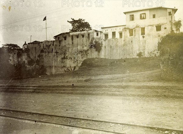 The fort'. A building with high walls near a small railway track is identified only as 'the fort'. Probably Kenya, 1906., Eastern Africa, Africa.