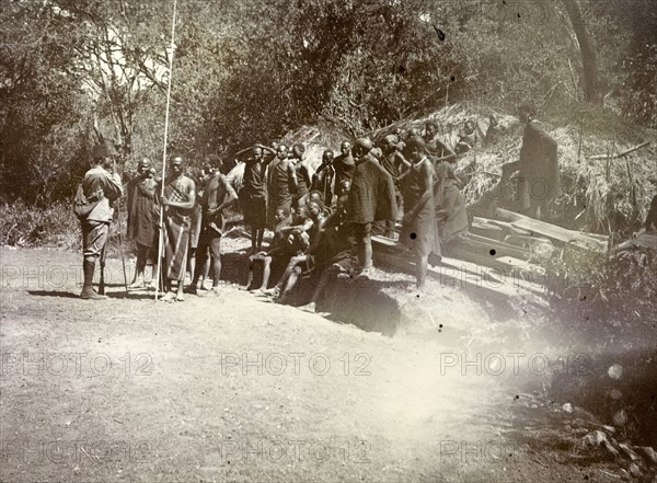 Kenyan 'road-makers'. A group of Kenyan men await instructions. They wear traditional dress and are captioned as 'Road makers'. British East Africa (Kenya), 1906. Kenya, Eastern Africa, Africa.