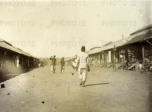 Indian bazaar, Nairobi. A man walks down a wide street lined with low shops, the main Indian bazaar or trading street of Nairobi. Nairobi, British East Africa (Kenya), 1906. Nairobi, Nairobi Area, Kenya, Eastern Africa, Africa.