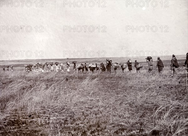 Safari to Lake Baringo. Frederick Stanbury's entourage of porters and servants make their way through the countryside carrying numerous items of luggage on a hunting safari to Lake Baringo. British East Africa (Kenya), 1906. Kenya, Eastern Africa, Africa.