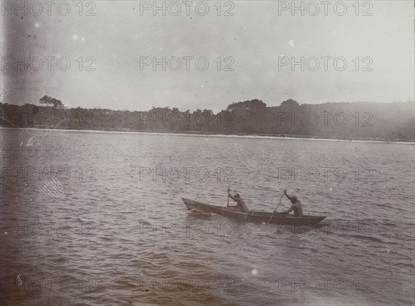 Canoe on Lake Victoria. Two men paddle a small wooden canoe on Lake Victoria. Lake Victoria, British East Africa (Kenya), 1906., Nyanza, Kenya, Eastern Africa, Africa.
