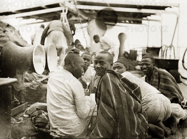 African soldiers in German service. African soldiers in the Shutztruppe (the German colonial defence force) share a joke together aboard a steamer travelling on Lake Victoria. German East Africa (Tanzania), 1906., Kagera, Tanzania, Eastern Africa, Africa.