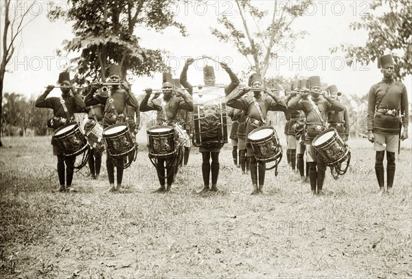 4th King's African Rifles Band. Portrait of a regiment of uniformed drummers in the 4th King's African Rifles Band, drumsticks poised. Uganda, circa 1928. Uganda, Eastern Africa, Africa.