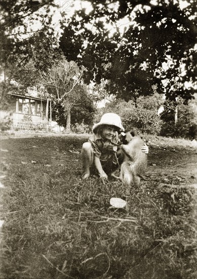 When you were about 5 1/2. A young Charles Trotter squats down to play with his pet Vervet monkey 'Marmaduke' in the family garden. Uganda, circa 1928. Uganda, Eastern Africa, Africa.