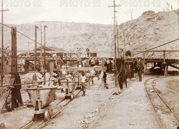 Premier Diamond Mine. African mine workers and a European overseer on the loading railway at the Premier Diamond Mine. Cullinan, South Africa, circa 1907. Cullinan, Gauteng, South Africa, Southern Africa, Africa.