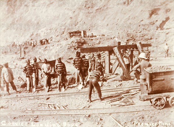 Convicts labouring at a diamond mine. African convicts on loading duty with a European overseer at the Premier Diamond Mine. Cullinan, South Africa, circa 1907. Cullinan, Gauteng, South Africa, Southern Africa, Africa.