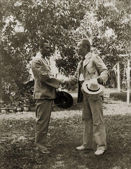 Directors of Anglo-Siamese Boundary Demarcation shake hands. Phya Suntara, Siamese Commissioner, shakes hands with Carlo Ferdinando Bozzolo, British District Magistrate. Janing, British Malaya (Malaysia), December 1901. Janing, Perak, Malaysia, South East Asia, Asia.